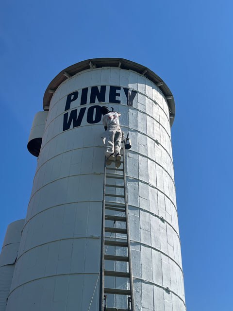 Hand-lettering the school name on the silo